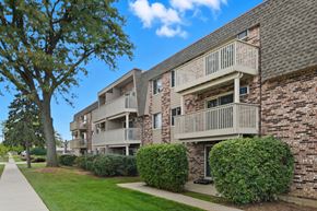 Buffalo Grove apartment for rent - A building with a balcony and a tree in front of it.