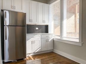 Chicago apartment for rent - A kitchen with a stainless steel refrigerator and white cabinets.