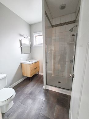 Chicago apartment for rent - A bathroom with a toilet, sink, and walk-in shower.