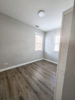 Chicago apartment for rent - A room with wooden flooring and two windows.