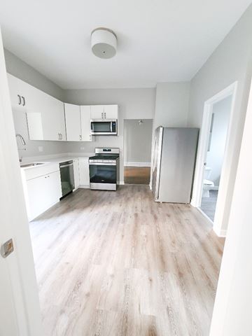 Chicago apartment for rent - A kitchen with white cabinets and a refrigerator.