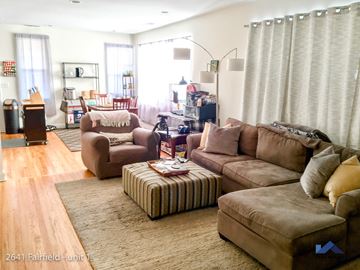 Chicago apartment for rent - A living room with brown furniture and a striped ottoman.