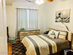 Chicago apartment for rent - A bedroom with a bed, dresser, and ceiling fan.