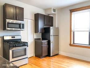Chicago apartment for rent - A kitchen with a stove, microwave, and refrigerator.