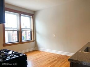 Chicago apartment for rent - A kitchen with a black stove top oven and a window with blinds.