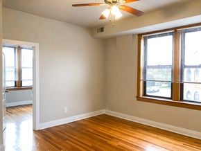 Chicago apartment for rent - A room with a ceiling fan and a window with blinds.