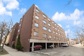 Chicago apartment for rent - a large brick building with a parking lot in front of it