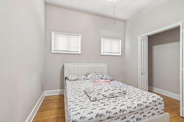Chicago apartment for rent - A bedroom with a bed and two windows.