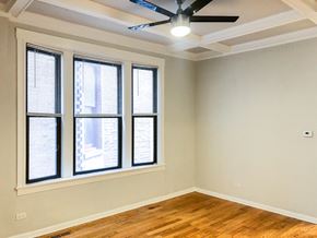Chicago apartment for rent - an empty room with three windows and a ceiling fan