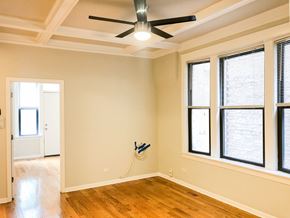Chicago apartment for rent - an empty living room with a ceiling fan and windows