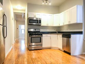 Chicago apartment for rent - an empty kitchen with stainless steel appliances and white cabinets