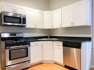 Chicago apartment for rent - a kitchen with stainless steel appliances and white cabinets