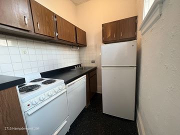 Chicago apartment for rent - A kitchen with a white stove and a white fridge.
