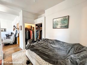Chicago apartment for rent - A bedroom with a bed, a chair, and a painting on the wall.