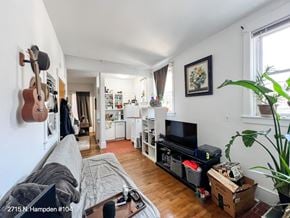 Chicago apartment for rent - A living room with a couch, a television, and a guitar hanging on the wall.