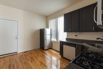 Chicago apartment for rent - A kitchen with a stove top oven and a refrigerator.
