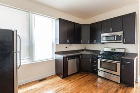 Chicago apartment for rent - A kitchen with black cabinets and stainless steel appliances.