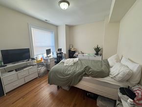 Chicago apartment for rent - A bedroom with a bed, dresser, and a television.
