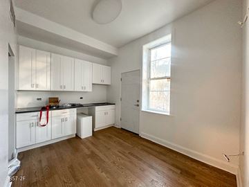 Chicago apartment for rent - A kitchen with white cabinets and a window.