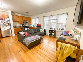 Chicago apartment for rent - A living room with a grey couch and a yellow blanket on a chair.
