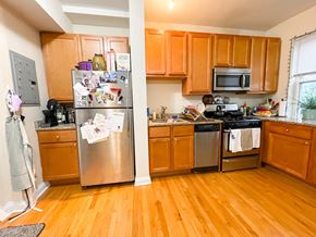 Chicago apartment for rent - A kitchen with wooden cabinets and a refrigerator with many magnets on it.