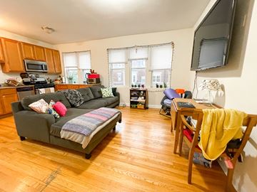 Chicago apartment for rent - A living room with a grey couch and wooden floors.