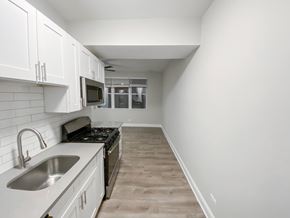 Chicago apartment for rent - A kitchen with white cabinets and a black stove top oven.