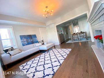 Chicago apartment for rent - A living room with a white couch and a blue and white rug.