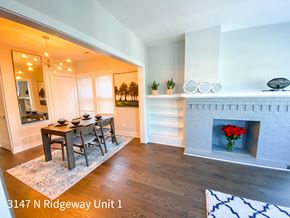 Chicago apartment for rent - A dining room with a fireplace and a vase of red roses.