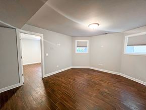 Chicago apartment for rent - A room with wooden floors and a window with blinds.