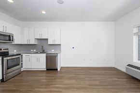 Denver apartment for rent - A kitchen with white cabinets and a wooden floor.