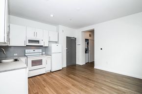 Denver apartment for rent - A kitchen with white appliances and wooden floors.