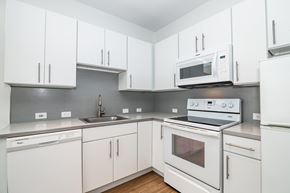 Denver apartment for rent - A white kitchen with a microwave on top of the stove.