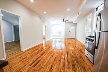 Chicago apartment for rent - A kitchen with a wooden floor and a refrigerator on the right side.