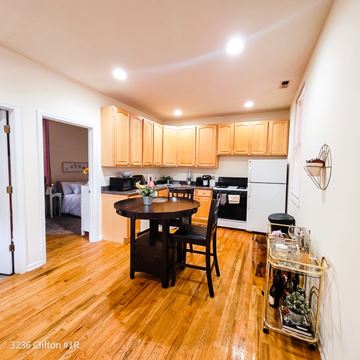 Chicago apartment for rent - A kitchen with wooden floors and a table with a vase of flowers on it.