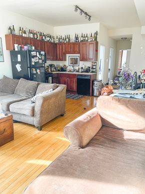 Chicago apartment for rent - A kitchen with a refrigerator covered in magnets and a dining table with chairs.