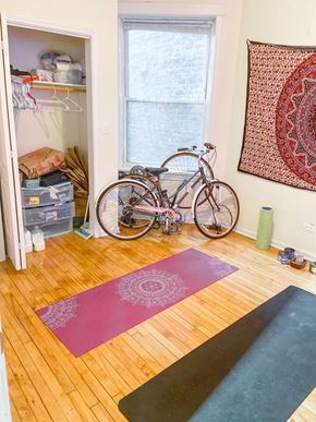 Chicago apartment for rent - A room with a yoga mat, a bicycle and a rug.