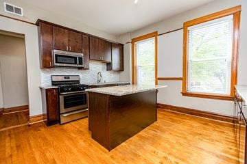 Chicago apartment for rent - A kitchen with wooden cabinets and a black island.