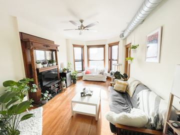 Chicago apartment for rent - A living room with a white couch and a fireplace.