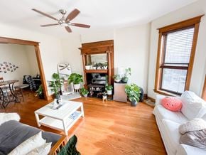 Chicago apartment for rent - A living room with a white couch, a coffee table, and a ceiling fan.