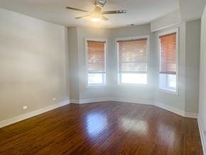 Chicago apartment for rent - an empty living room with wood floors and a ceiling fan