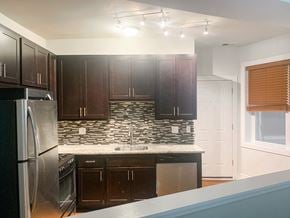Chicago apartment for rent - a kitchen with dark wood cabinets and a stainless steel refrigerator
