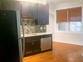 Chicago apartment for rent - a kitchen with dark wood cabinets and a refrigerator