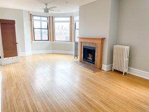 Chicago apartment for rent - A room with a fireplace and a fan on the ceiling.