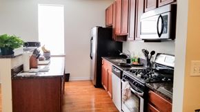 Chicago apartment for rent - a kitchen with wooden cabinets and a stove and a microwave