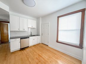 Chicago apartment for rent - A kitchen with white cabinets and a wooden floor.