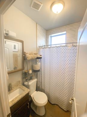 Chicago apartment for rent - A white toilet in a bathroom with a shower curtain.