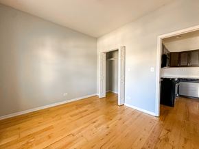 Chicago apartment for rent - A room with wooden floors and a white door.