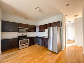 Chicago apartment for rent - A kitchen with wooden floors and stainless steel appliances.