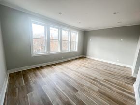 Chicago apartment for rent - A room with wooden flooring and a window overlooking a cityscape.